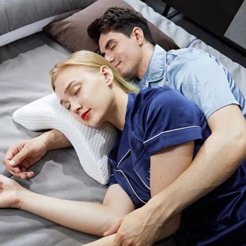 Couples comfort pillow with curved ergonomic design for spinal alignment and supportive sleep positioning model shot
