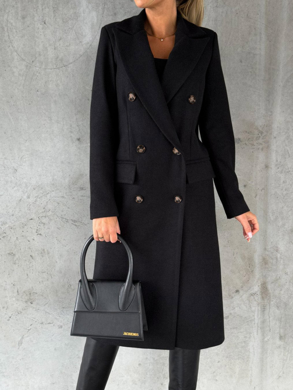 Double breasted long coat in black color with lapel collar and tailored fit for women model shot (Color: Black)