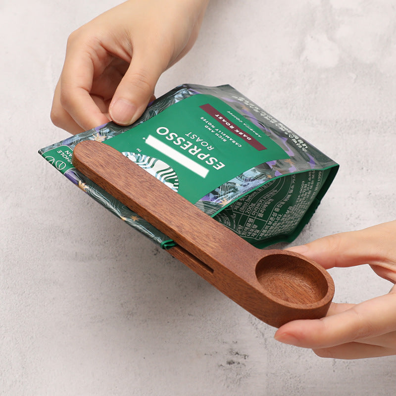 Dark colored dual-purpose wooden measuring spoon and sealing clip in use (Color: Dark)