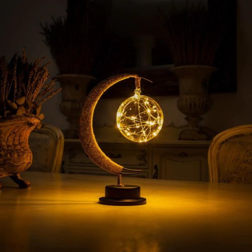 Enchanted lunar lamp with crescent moon design warm ambient lighting and decorative glass globe