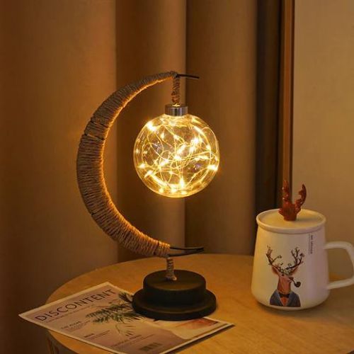 Enchanted lunar lamp with crescent moon design warm ambient lighting and decorative glass globe product shot
