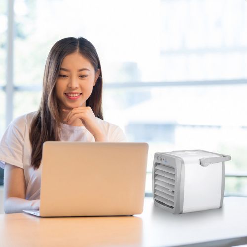 Mini air conditioner with cooling fan humidifier function and portable desktop design depiction of use on a desk
