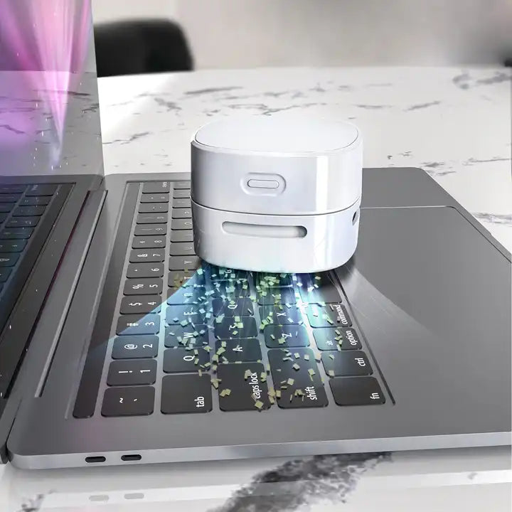 Mini desktop vacuum cleaner cordless device for cleaning desk keyboard and small debris depiction of cleaning a laptop keyboard