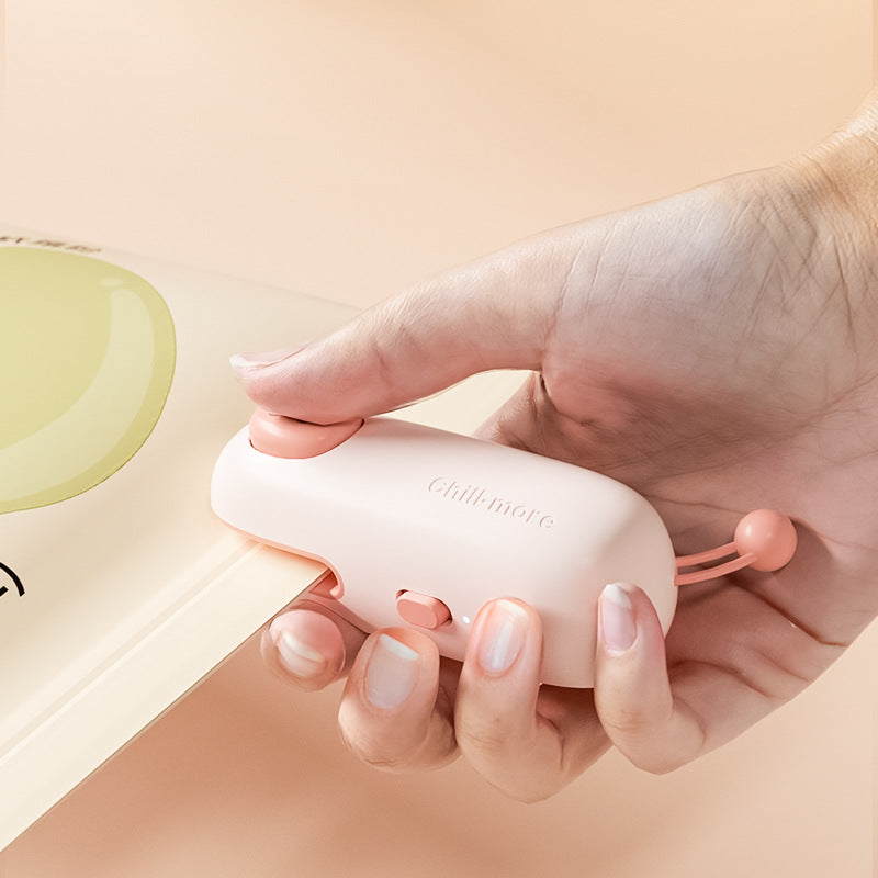 Mini portable bag sealer with rechargeable compact design for resealing snack bags and keeping food fresh depiction of use