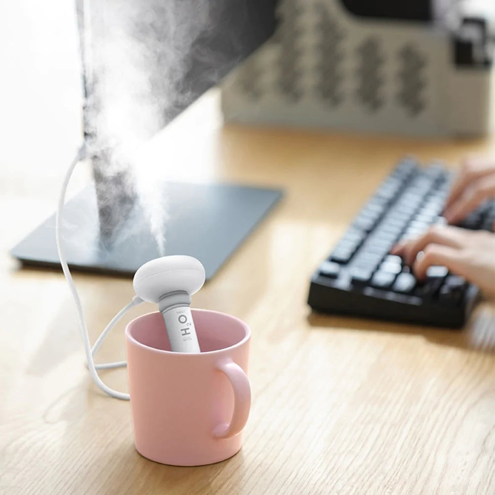 Portable air humidifier compatible with bottles and cups for travel and personal use depiction of use with a cup