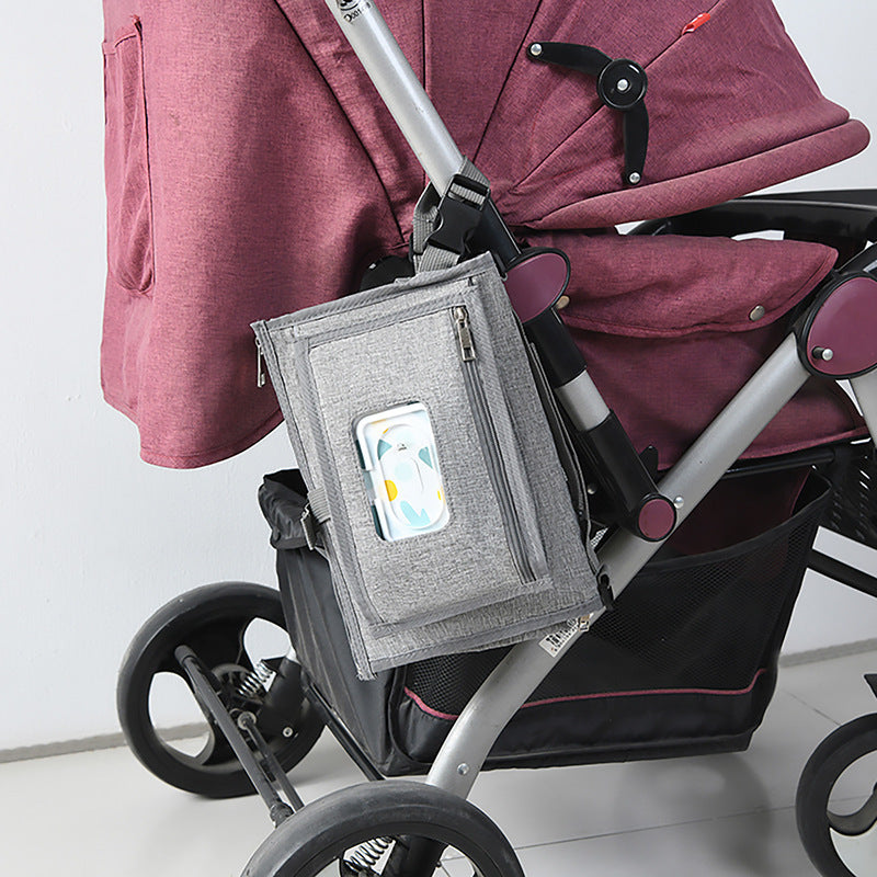 Portable folding baby diaper changing pad designed for travel, providing a clean and comfortable surface for diaper changes on the go hanging on a baby car