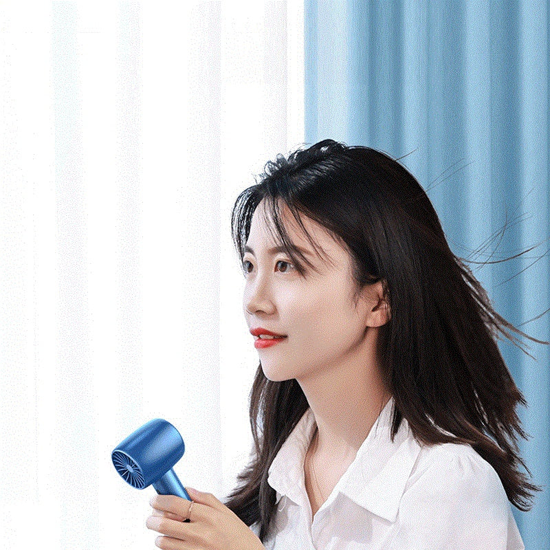 Portable handheld turbo fan with three speed settings designed for powerful personal cooling on the go depiction of use