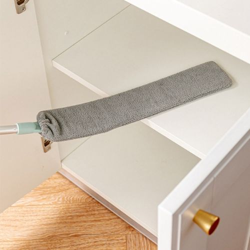Retractable gap dust cleaner with microfiber head for cleaning under furniture and tight spaces depiction of use