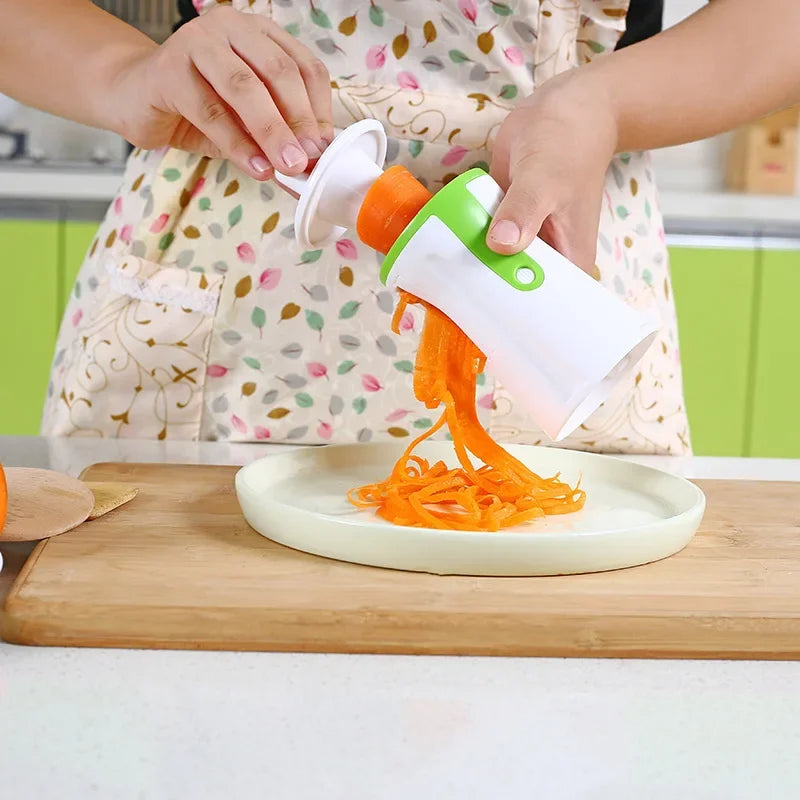 Vegetable spiralizer with interchangeable blades for creating zucchini noodles spirals and ribbon cuts depiction of spiralizing carrot