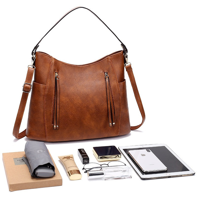 Women’s large capacity shoulder bag with soft leather look and multiple compartments for everyday use depiction of items that fit inside the bag