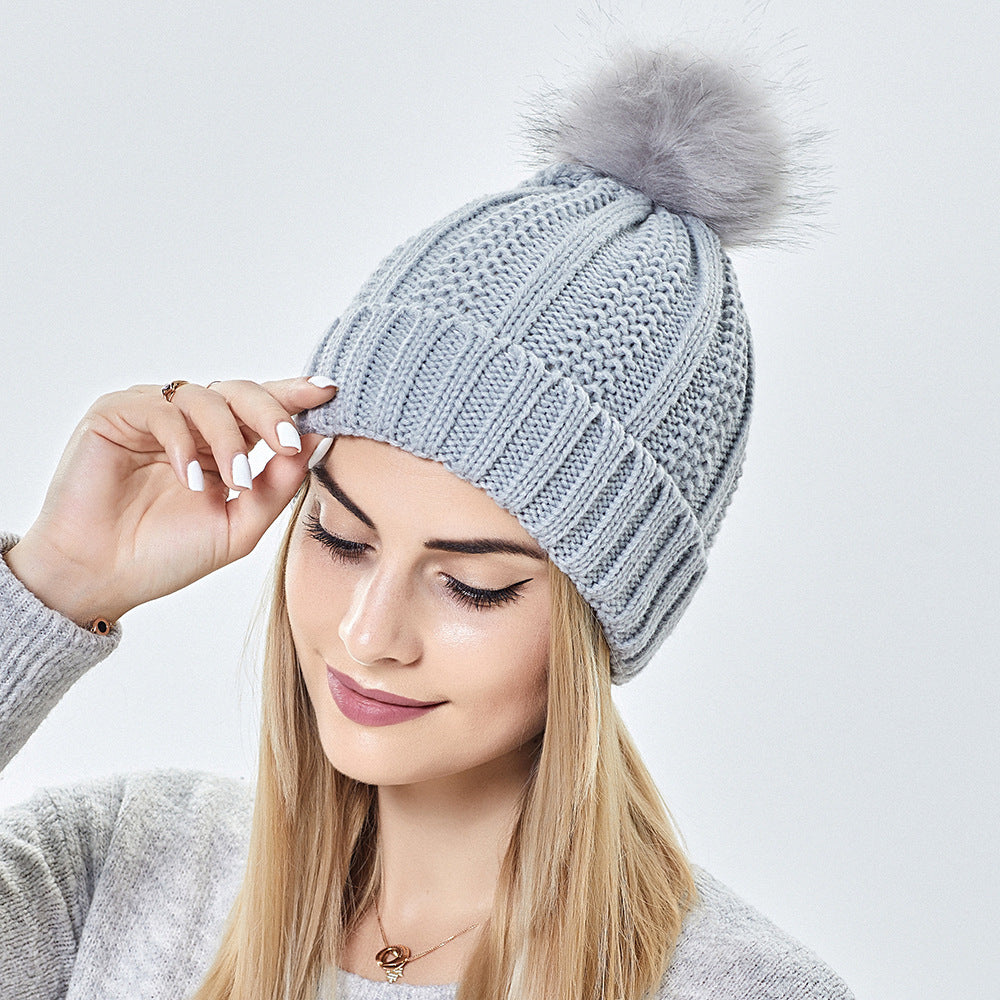 Women’s satin-lined knit beanie with faux fur pom pom designed to keep hair protected and warm in winter