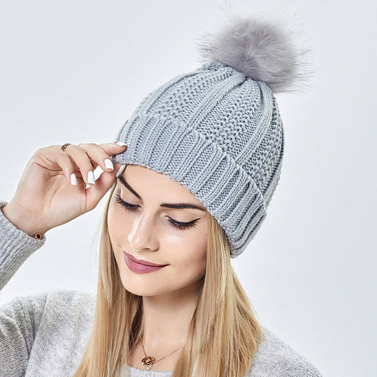 Women’s satin-lined knit beanie with faux fur pom pom designed to keep hair protected and warm in winter